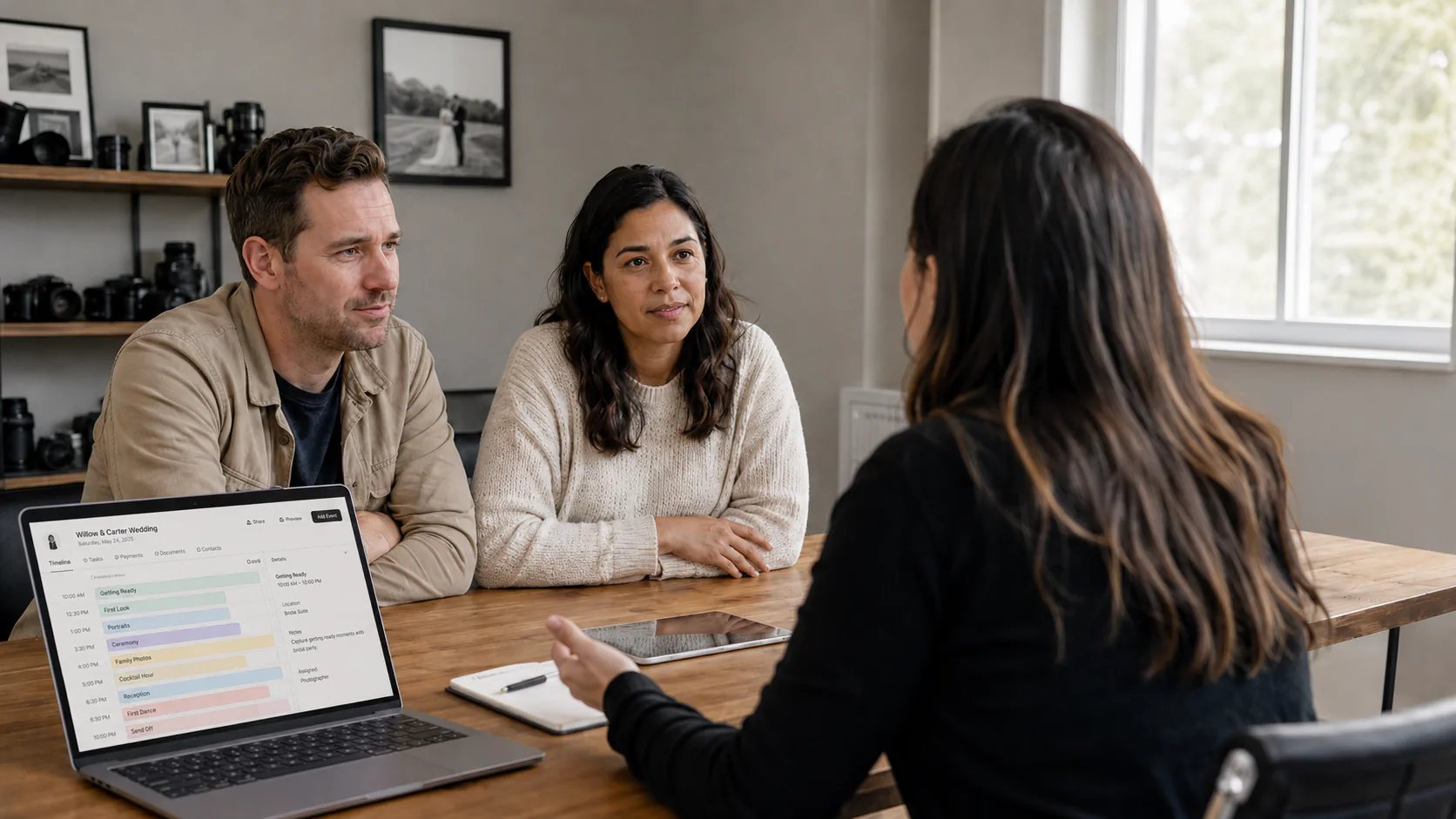 A wedding photographer discussing client intake and shoot planning with a couple.